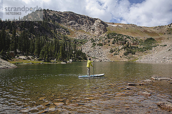 Mann paddelt im Sommer auf einem See