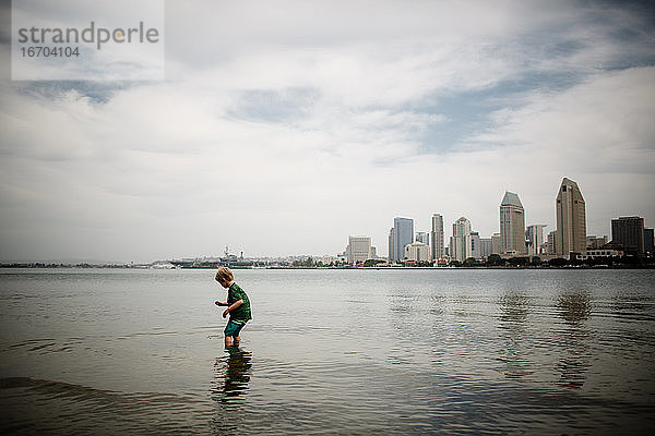 Sechs Jahre alter Junge watet in der Coronado-Bucht  Skyline von San Diego