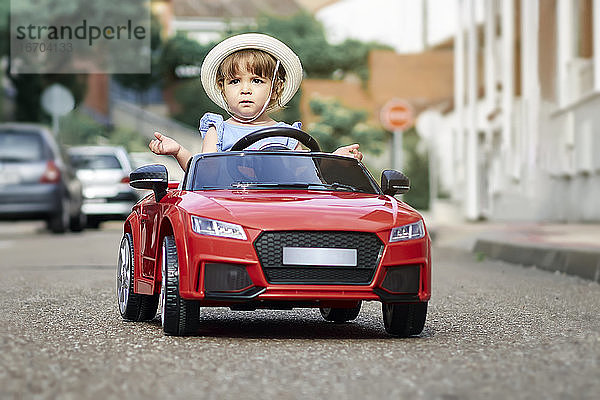 Ein Mädchen fährt ein Spielzeugauto