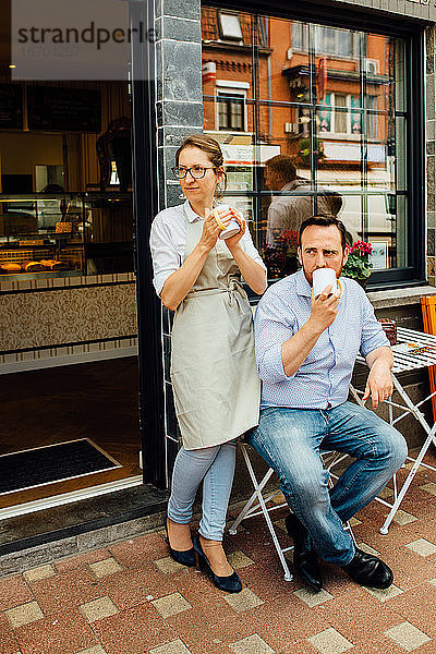 Mann und Frau  Cafébesitzerpaar beim Teetrinken am Eingang eines Cafés