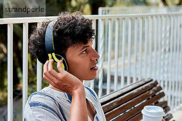 Porträt eines jungen Mannes mit Afro-Haar hört Musik in