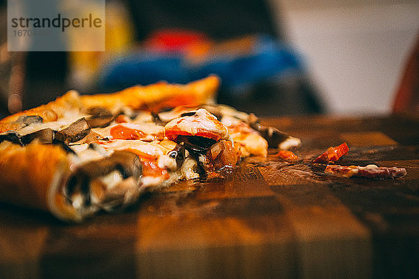 Selektiver Fokus auf italienische Pizza  Gewürze in Mühlen  Flasche und Glas Wein auf Holztischplatte