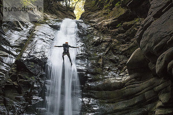 Keine Hände beim Abseilen in der Mitte eines Wasserfalls.