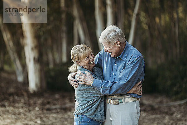 Porträt eines älteren erwachsenen Paares  das sich im Wald umarmt