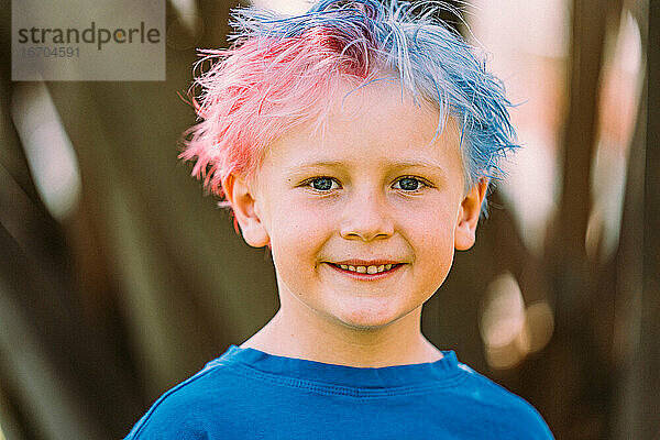 Junge mit gefärbtem Haar lächelt in die Kamera