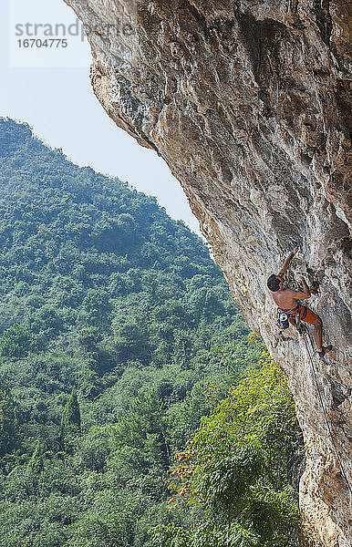 Mann beim Klettern in Odin's Den in Yangshuo  einem Klettermekka in China