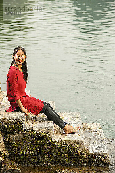 schöne Frau  die am Fluss Li in Yangshuo sitzt