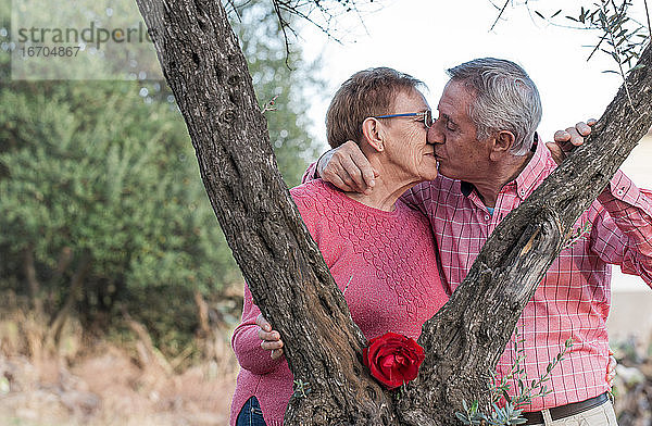 Verliebtes älteres Ehepaar  das sich im Garten küsst
