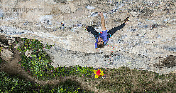 Mann beim Klettern auf dem Kalksteinfelsen Weißer Berg in Yangshuo