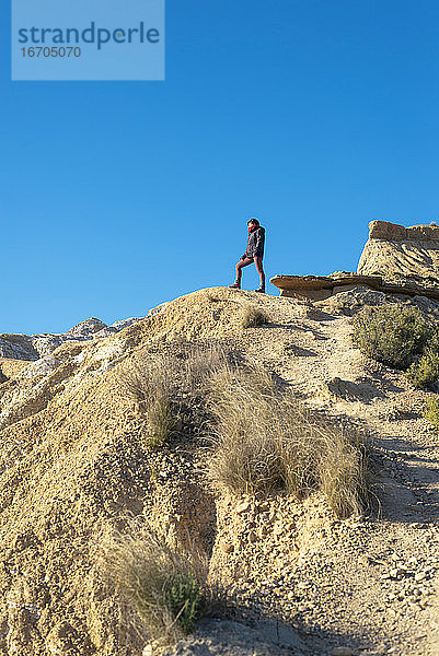 Seitenansicht einer Frau  die auf einem Hügel steht und wegschaut