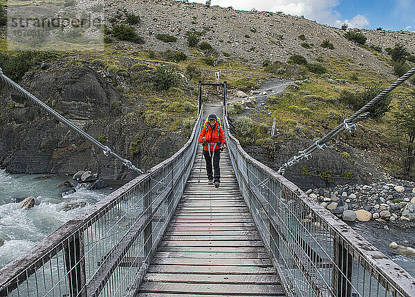 Wanderin beim Überqueren einer Brücke im Torres del Paine-Nationalpark