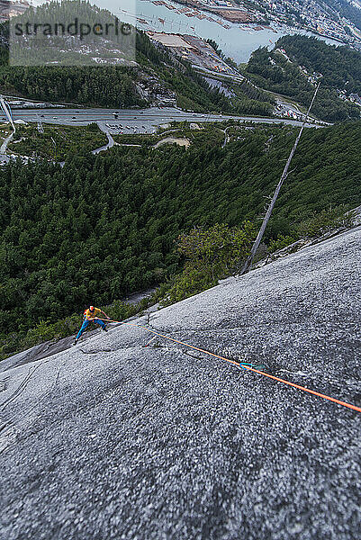 Mann beim Klettern und Schwingen mit freiem Blick Squamish Chief