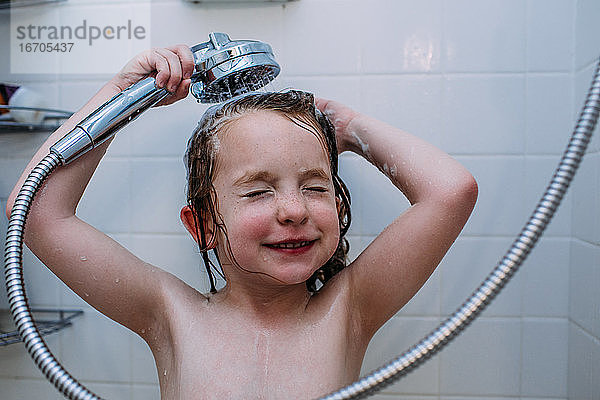 Nahaufnahme eines Kindes beim Haarewaschen in der Dusche