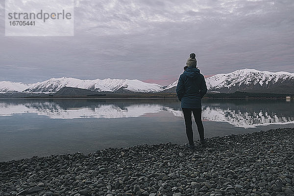 Junge Frau in einer blauen Jacke vor dem Lake Tekapo  NZ