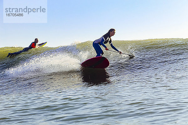 SUP-Surferin bei Sonnenuntergang