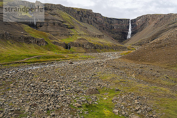 Fernsicht auf Touristen  die zum Hengifoss-Wasserfall wandern  Island