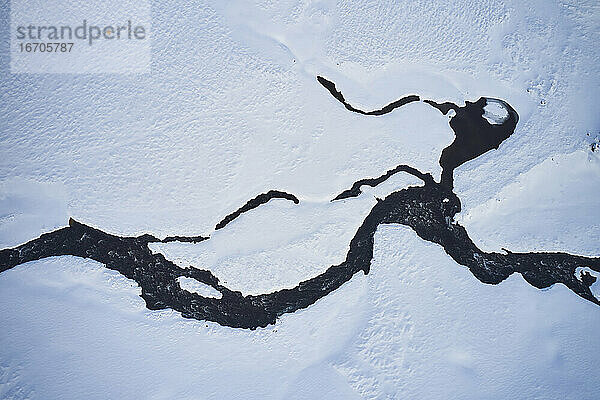 Gefrorener Fluss in einer Bergregion im Winter