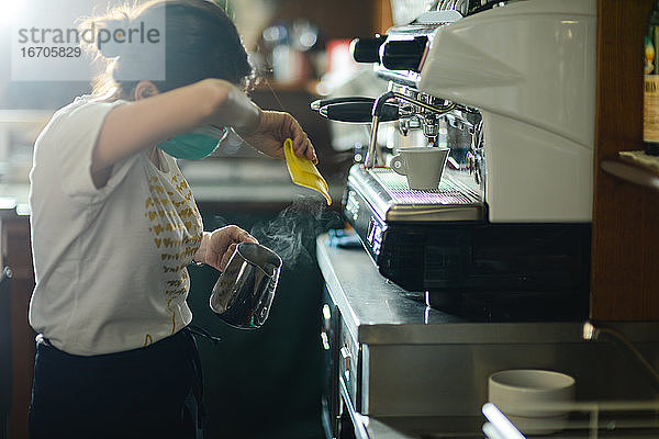 Hände einer jungen erwachsenen kaukasischen Barista-Frau bei der Arbeit