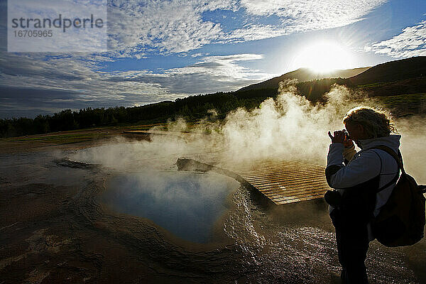 Reife Frau beim Fotografieren eines geothermischen Pools in Island