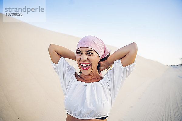 Junge Frau mit rosa Kopftuch kämpft gegen Krebs