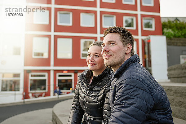 Glückliches Paar ruht sich in der Nähe eines städtischen Gebäudes aus