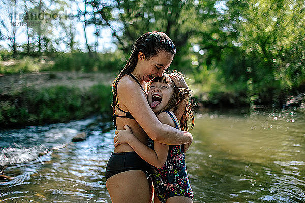 Zwei Mädchen umarmen sich und lachen an einem warmen Sommertag