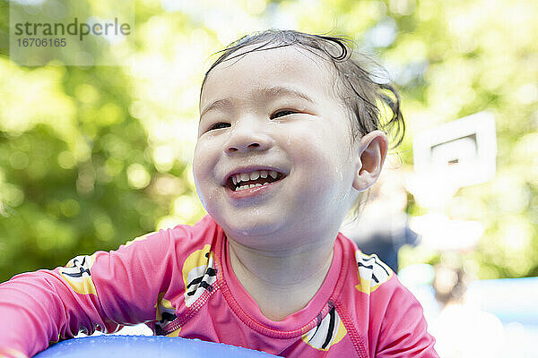 Porträt des glücklichen Kleinkindes Mädchen lächelnd im Hinterhof Schwimmbad