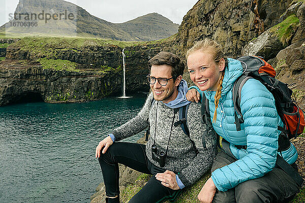 Vergnügte junge Reisende ruhen sich am Fjord aus