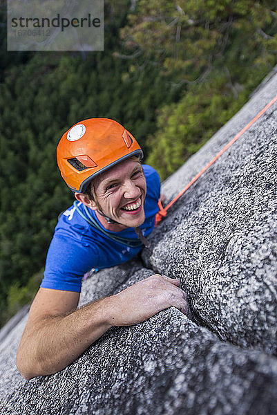 Kletterer schaut nach oben und lacht beim Klettern mit Helm Chief