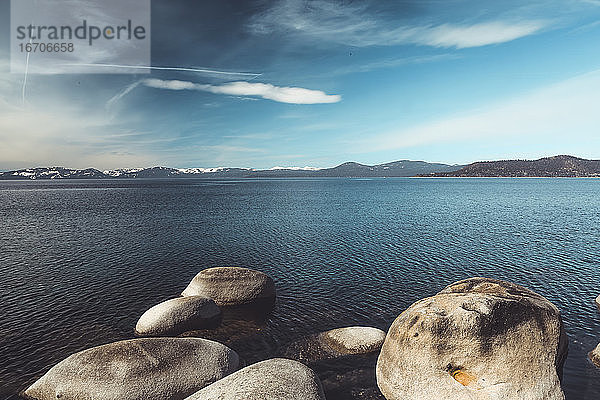 Weitwinkelaufnahme des Lake Tahoe mit schneebedeckter Bergkette im Hintergrund