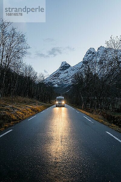 Campervan mit hellen Lichtern steht auf Straße nahe Trollstigen  Trollstigen  Norwegen  Europa