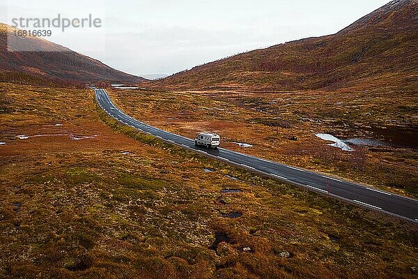 Drohnenaufnahme  Campervan auf einer Straße mit herbstlicher Vegetation  Fylkesvei 862  Melfjordbotn  Senja  Norwegen  Europa