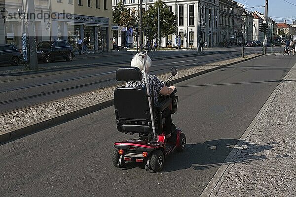 Ältere Frau mit einem elektrischen Rollstuhl auf einen Fahrradweg  Potsdam  Brandenburg  Deutschland  Europa