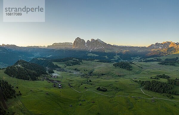 Drohnenaufnahme  Seiser Alm mit Wiesen und Hütten vor Langkofel und Plattkofel  Sonnenaufgang  Seiser Alm  Südtirol  Italien  Europa