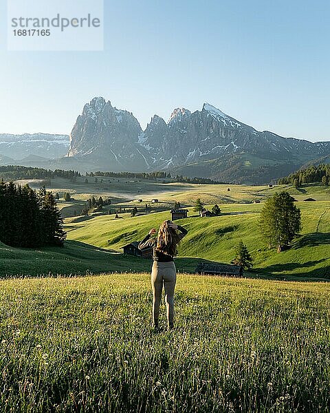 Frau steht auf Wiese  hinten Langkofel und Plattkofel  Seiser Alm  Südtirol  Italien  Europa