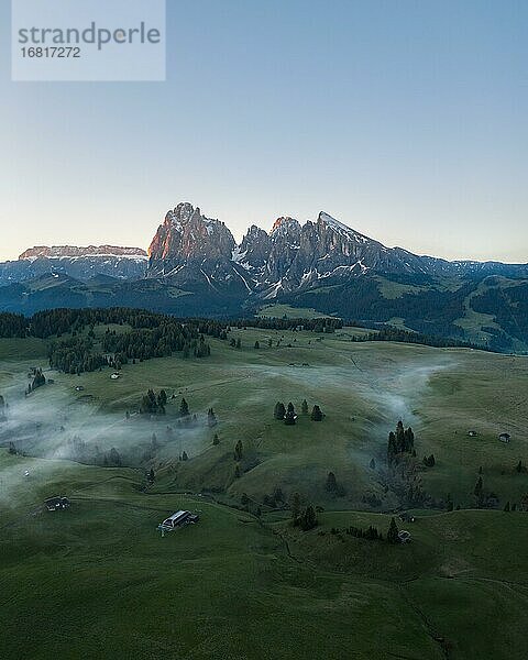 Drohnenaufnahme  Seiser Alm mit Wiesen  und Hütten vor Langkofel und Plattkofel  Sonnenaufgang  Seiser Alm  Südtirol  Italien  Europa