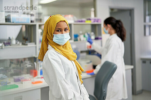 Portrait selbstbewusste Wissenschaftlerin in Hijab und Gesichtsmaske