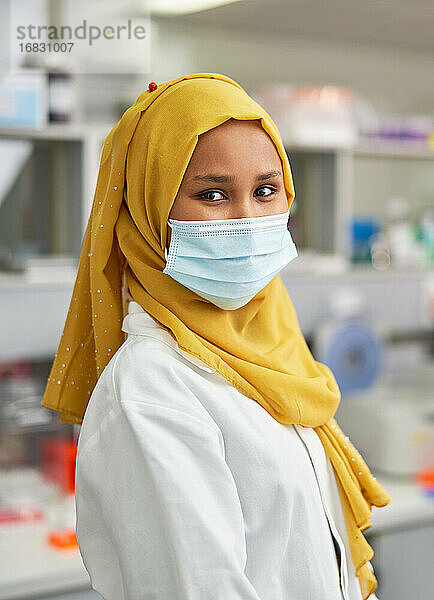 Porträt selbstbewusste Wissenschaftlerin in Hidschab und Gesichtsmaske im Labor