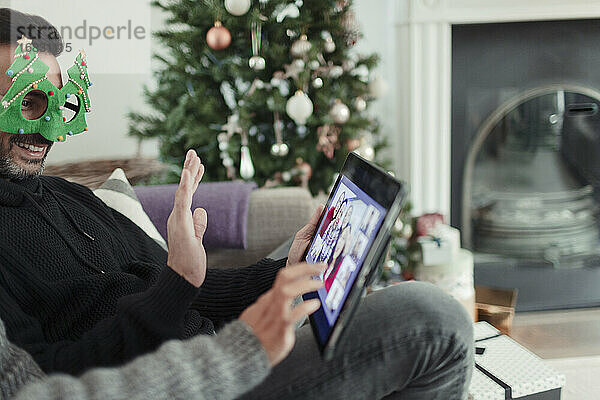 Paar chattet zu Weihnachten per Video mit der Familie auf einem digitalen Tablet