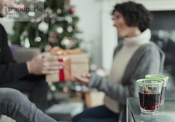 Glückliches Paar öffnet Weihnachtsgeschenke im Wohnzimmer
