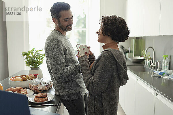 Glückliches Paar im Gespräch in der Morgenküche
