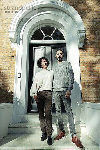 Porträt zuversichtlich Paar an gewölbten Haustür auf sonnigen Haus stoop
