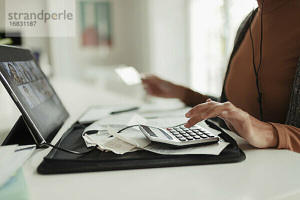 Frau mit Taschenrechner und Quittungen zahlen Rechnungen an digitalen Tablet
