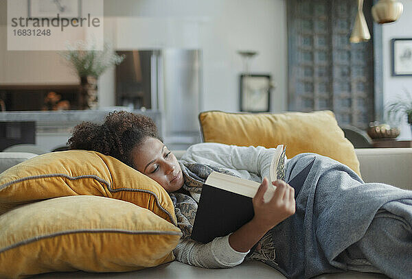 Frau entspannend und Lesung Buch auf Sofa im Wohnzimmer