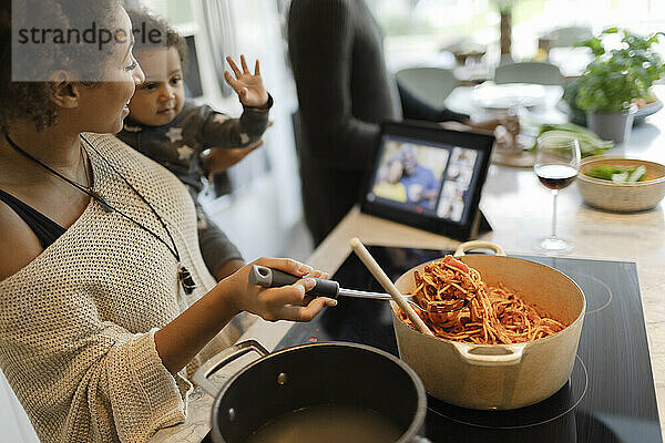 Mutter und Baby Tochter kochen Spaghetti und Video-Chat