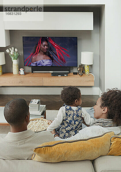 Familie beim Fernsehen auf dem Wohnzimmersofa