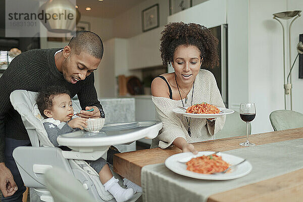 Paar essen Spaghetti und Fütterung Baby Tochter am Esstisch