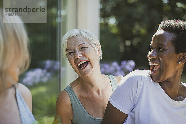 Glückliche ältere Frauen Freunde lachen auf Sommerterrasse