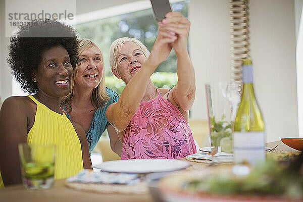 Senior Frauen Freunde nehmen Selfie am Esstisch