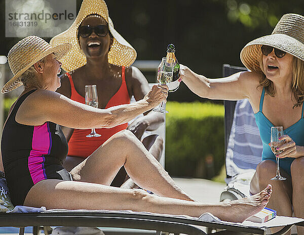 Glückliche ältere Frauen Freunde trinken Champagner auf sonnigen Sommer-Terrasse